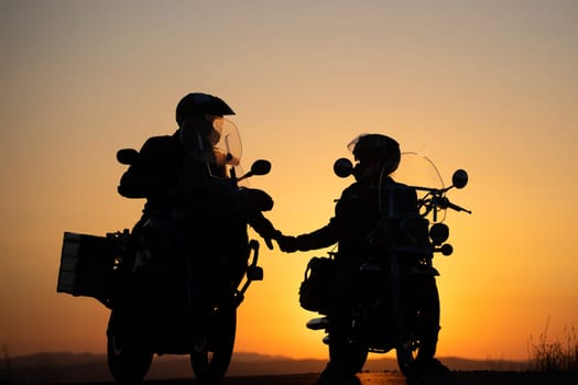 Motorcycle couple in sunset with classic motorcycle