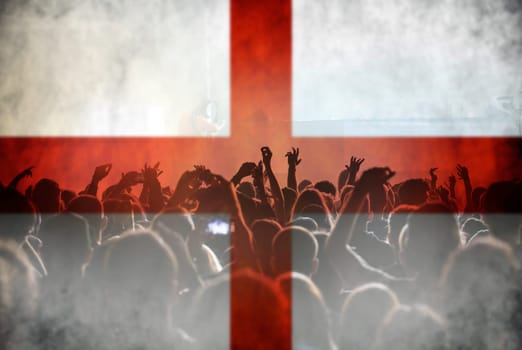 Football fans supporting England - crowd celebrating in stadium with raised hands against England flag