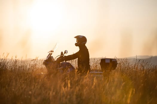Motorcycle driver riding on countryside hills. Travel and sport, speed and freedom concept