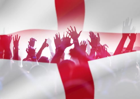 Football fans supporting England - crowd celebrating in stadium with raised hands against England flag