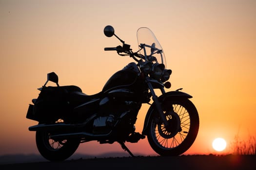 Vintage motorcycle on country road in the sunset