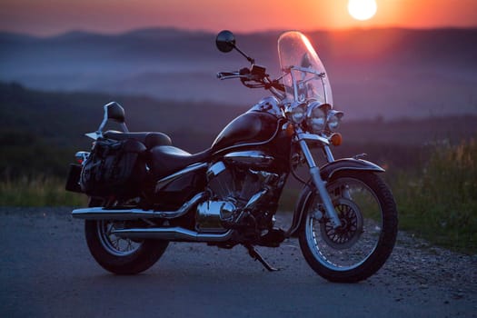 Vintage motorcycle on country road in the sunset