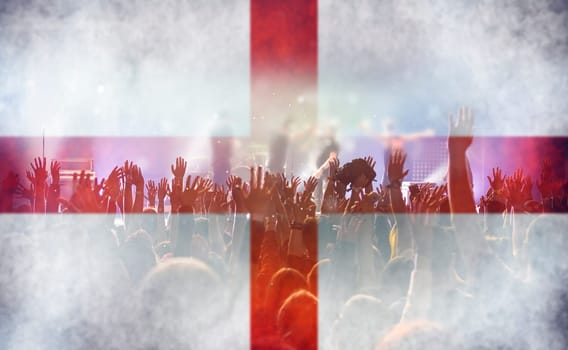 Football fans supporting England - crowd celebrating in stadium with raised hands against England flag