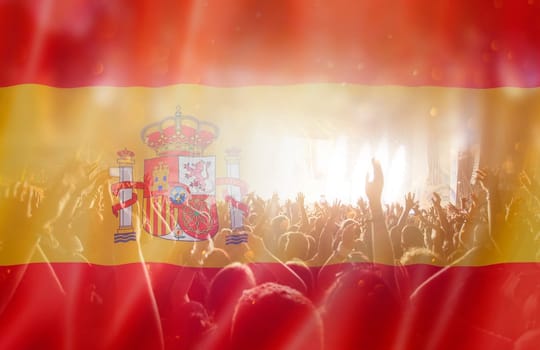 Soccer fans supporting Spain - crowd celebrating in stadium with raised hands against Spain flag