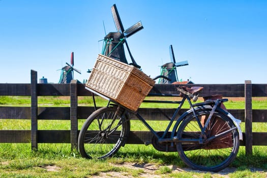 Bicycle with windmill and blue sky background. Scenic countryside landscape close to Amsterdam in Netherlands.