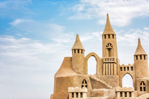 Sandcastle during a sunny day with blue sky background. Concept for summer, vacation, relax and fun.