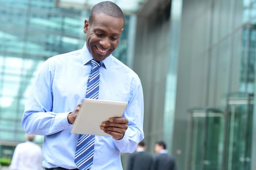 Smiling businessman using his new digital tablet