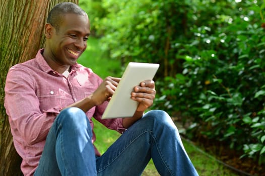 Happy man watching social media in a digital tablet