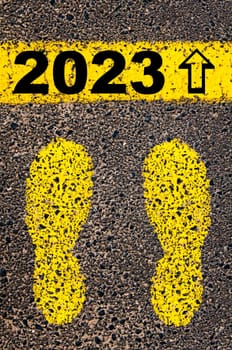 Conceptual image with yellow paint footsteps on the road in front of horizontal line over asphalt stone background. Word XXXXXXXX