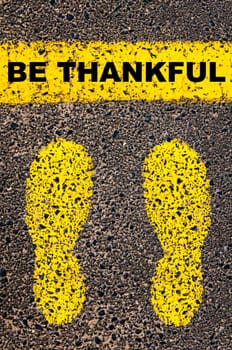 Conceptual image with yellow paint footsteps on the road in front of horizontal line over asphalt stone background. Word XXXXXXXX