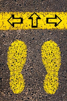 Conceptual image with yellow paint footsteps on the road in front of horizontal line over asphalt stone background. Word XXXXXXXX