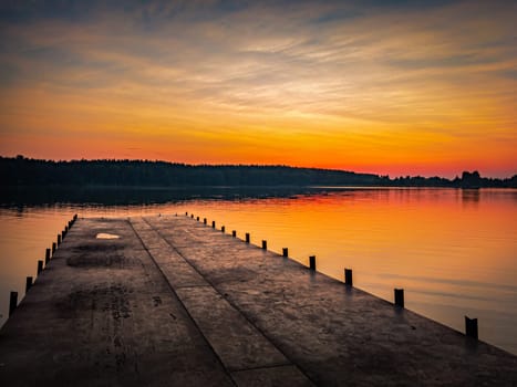 Sunset at lake, sky with clouds in background and pier in foreground