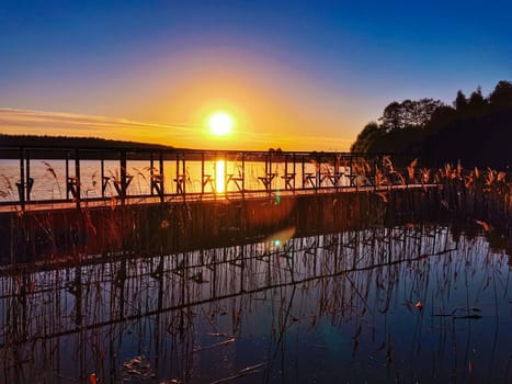 Sunset at lake, sky with clouds in background and pier in foreground