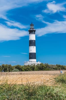 The Chassiron lighthouse with black and white stripes on blue sky, on the island of Oléron in France