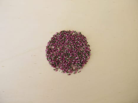 Dried pink heather flowers on a wooden board