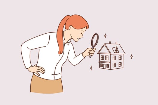 Searching for new house and real estate concept. Young positive business woman standing using magnifying glass zooming to see house or residential building details for making deal