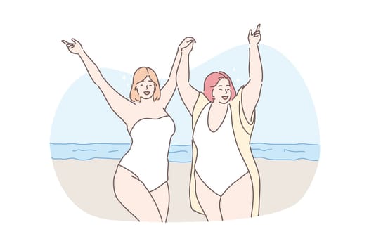 Body positive, vacation, travelling, holiday concept. Young happy obese thick women friends tourists on ocean beach holding hands together. Summer rest or recreation on sea coast and active lifestyle.