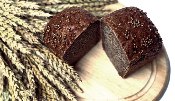 fresh bread and ears of wheat, isolated against white background