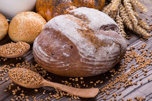 Assortment of baked bread on wooden table background