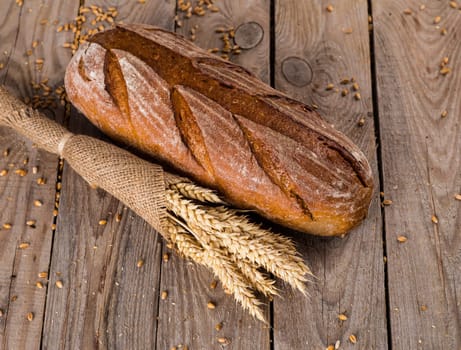 Two whole fresh challah bread with poppy and sesame seeds and honey wooden background