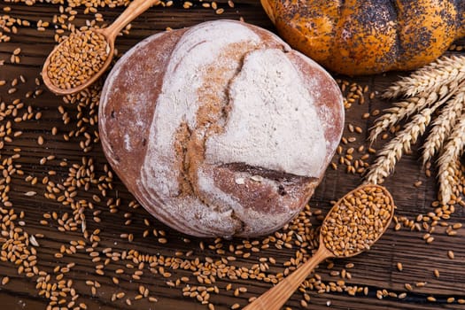 Assortment of baked bread on wooden table background