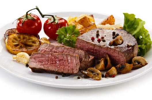 Steaks, baked potatoes and vegetable salad