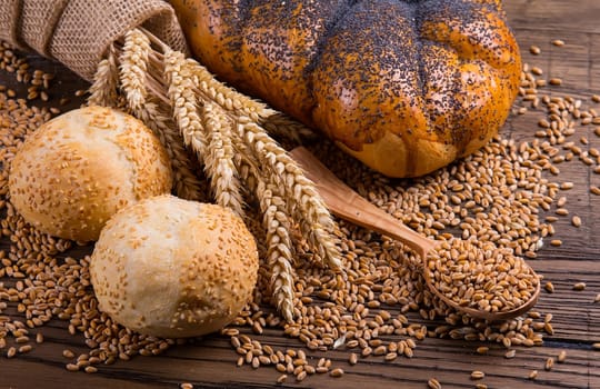 Assortment of baked bread on wooden table background