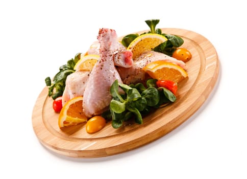Raw pork chops on cutting board and vegetable