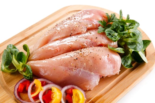 Raw pork chops on cutting board and vegetable