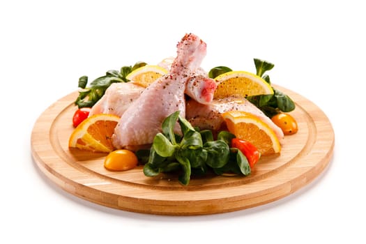 Raw pork chops on cutting board and vegetable