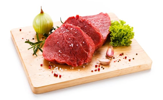 Raw pork chops on cutting board and vegetable
