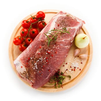 Raw pork chops on cutting board and vegetable