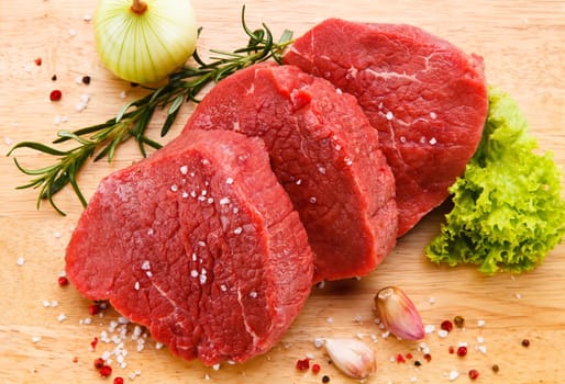 Raw pork chops on cutting board and vegetable