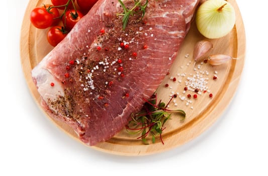 Raw pork chops on cutting board and vegetable