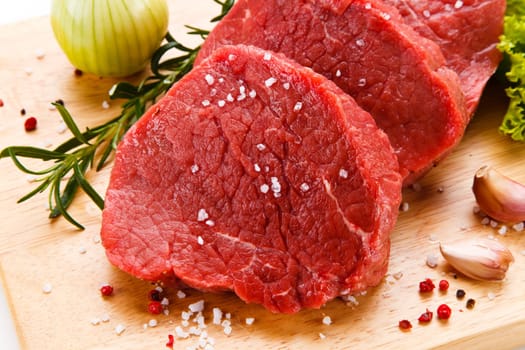 Raw pork chops on cutting board and vegetable