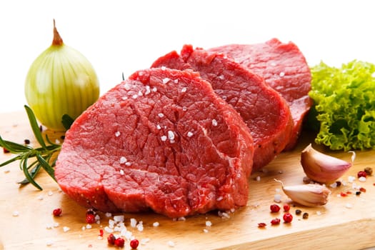Raw pork chops on cutting board and vegetable