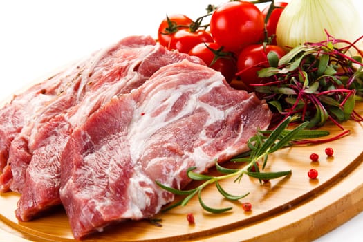 Raw pork chops on cutting board and vegetable