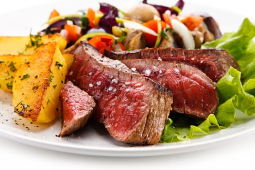 Steaks, baked potatoes and vegetable salad