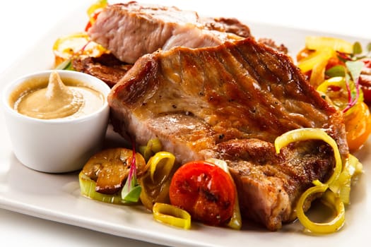Roasted steaks with vegetables on white plate