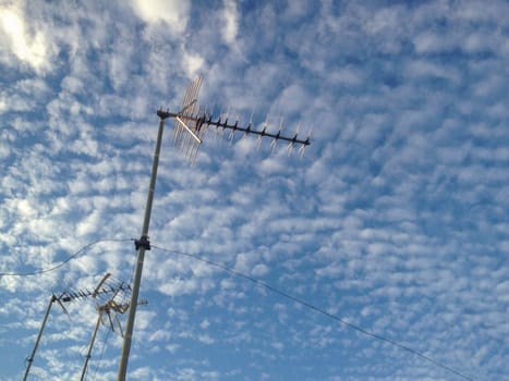 Domestic Tv antennas over blue cloudy sky. Selective focus