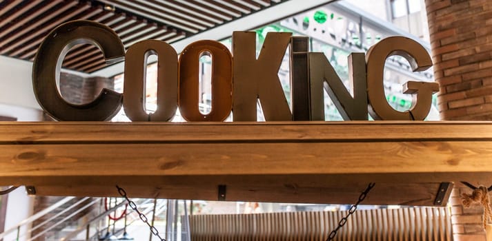 Wooden cooking letters over appetizers cart. Catering decoration concept