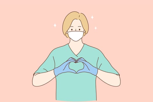 Doctors help and love, safety and care during coronavirus pandemic concept. Woman professional medic or nurse in protective face mask, gloves and green working uniform forming heart with fingers