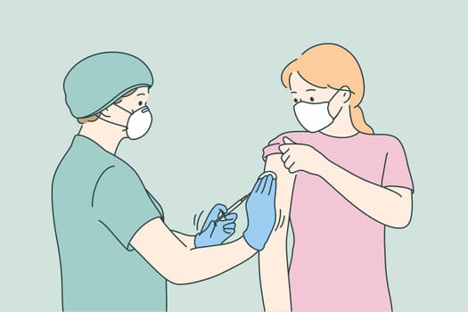 Woman doctor in protective medical mask and uniform holding syringe before making injection to young female patient in medical clinic. Vaccination, Covid-19 coronavirus vaccine concept
