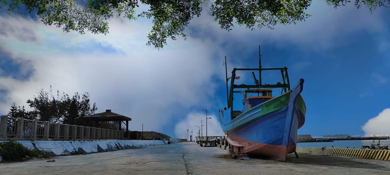 The nice sky with old fishport with wooden boat