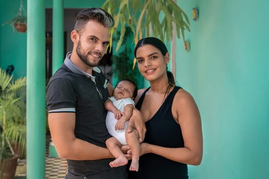 Photo of a baby in the arms of a woman and a man