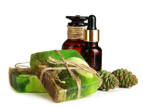 Hand-made soap and bottles of fir tree oil, isolated on white