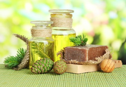 Hand-made soap and bottles of fir tree oil on bamboo mat