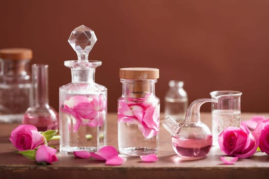alchemy and aromatherapy set with rose flowers and flasks