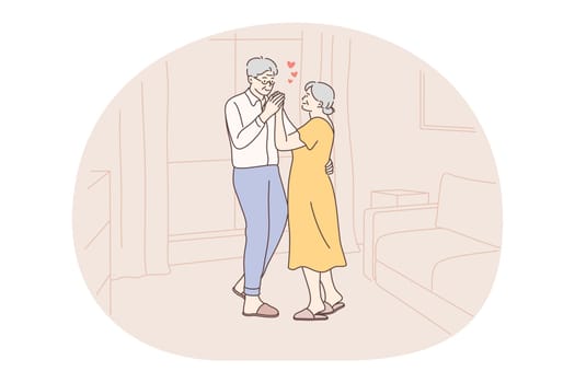 Senior elderly couple living happy active lifestyle concept. Mature aged couple pensioners woman and man standing hugging and feeling love to each other at home. Retiree, pensioner happiness