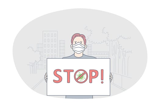 Danger or coronavirus infection epidemic, protective facial mask, pandemic concept. Young man in medical protective mask standing with sign stop in hands outdoors. Prevention of spreading outbreak